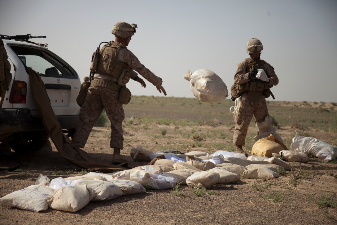 Marines with Company B, 1st Battalion, 23rd Marine Regiment, out of Louisiana, unload thousands of pounds of illegal drugs from a vehicle during interdiction operations in southwestern Afghanistan, May 9. Marine Heavy Helicopter Squadron 463 and 1st Battalion, 23rd Marine Regiment supported efforts to disrupt the enemy's drug smuggling operations. Such missions have proven effective in disrupting the enemy's movement and limiting their finances from the illegal drug trade.