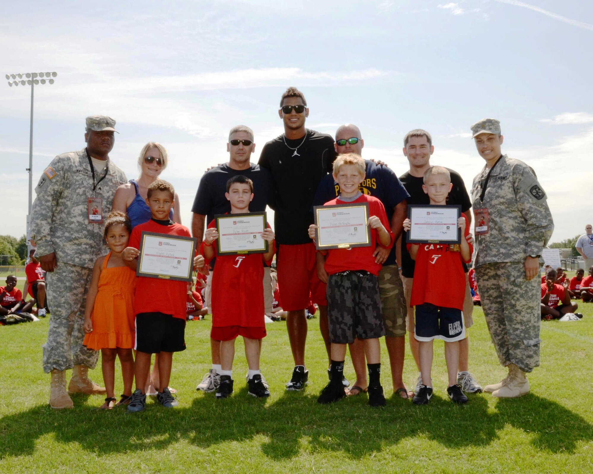 MACDILL AIR FORCE BASE, Fla. – United Services Organization Tampa Bay recently gave some families the experience of a lifetime.  Two military families from the 927th Air Refueling Wing received professional quarterback training from the Tampa Buccaneers during the week-long course.  Framed by their Army escorts, on the far left stands 1st Lt. Michelle Rykard, a ??? with the 63rd Air Refueling Squadron, and her son Khaleb Rykard, in the center is Tampa Bucaneers quarterback Josh Freeman, and on the far right is Capt. Chad Metiva,  a ??? with the 63rd Air Refueling Squadron standing with his son, Cameron Metiva.  (Photo courtesy of Josh Freeman Football Camp)
