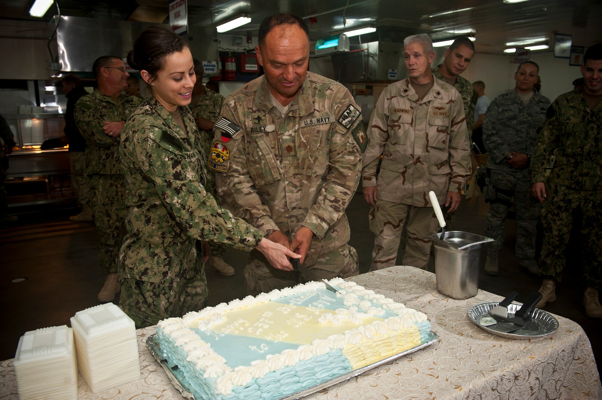 Left, Petty Officer 2nd Class Alicia Buchanan and Chaplain (Lt. Cmdr.) Frank Riley cut a birthday cake during a celebration at the Transit Center at Manas, Kyrgyzstan, Oct. 13, 2012. Joint service members celebrated the Navy's 237th birthday together at the Transit Center. Buchanan is a U.S. Naval Forces Central Forward Headquarters help desk technician deployed from Marine Corps Air Station Miramar, Calif. Riley is a NAVCENT FWD HQ chaplain deployed from Camp Pendleton, Calif. (U.S. Air Force photo/Senior Airman Brett Clashman)