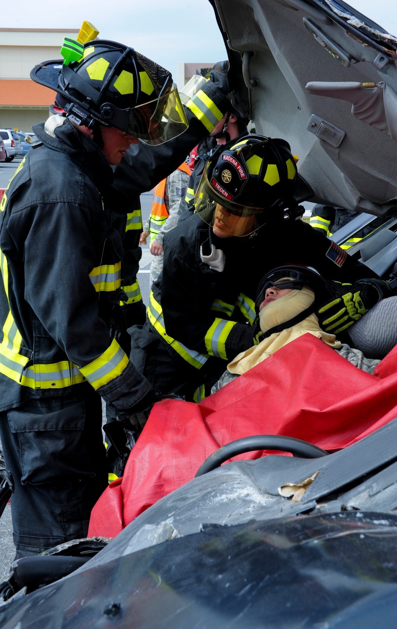 Firefighters from the 18th Civil Engineer Group reach Capt. Craig Nakagawa, a chaplain from the 18th Wing, who plays a casualty during a vehicle extrication demonstration on Kadena Air Base, Japan, Oct. 12, 2012. The event was one of the last to mark Fire Prevention Week. (U.S. Air Force photo/Airman 1st Class Justin Veazie)
