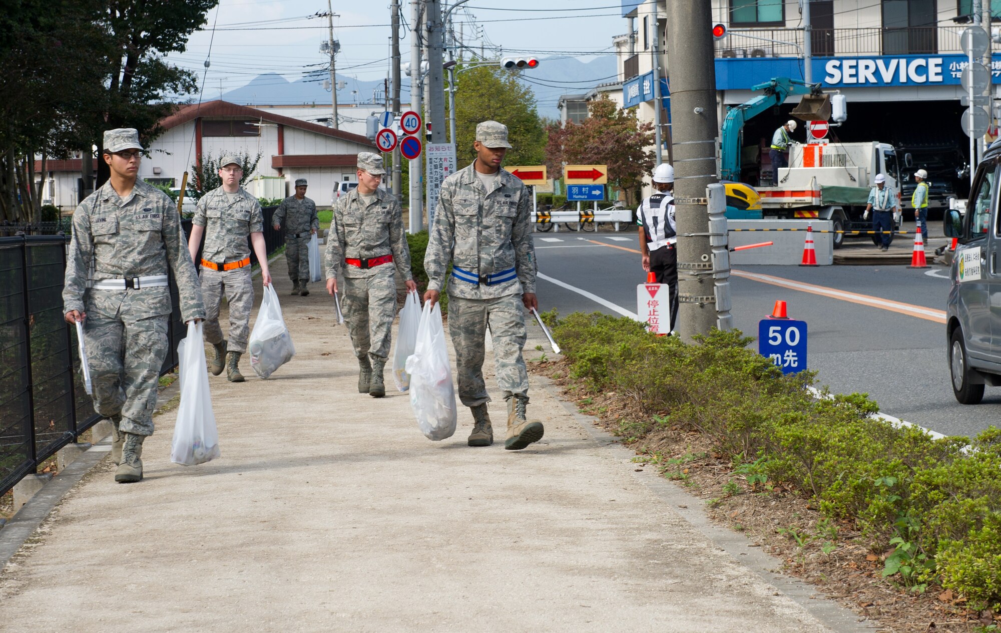MIZUHO TOWN, Japan -- Airmen from Yokota Air Base walk along the streets of Mizuho, Japan, to pick up trash during a monthly clean-up, Oct. 11, 2012. The clean-up efforts largely serve as a way to get Airmen into the community and meet their neighbors, putting a face to the Airmen of Yokota. (U.S. Air Force photo by Senior Airman Andrea Salazar)
