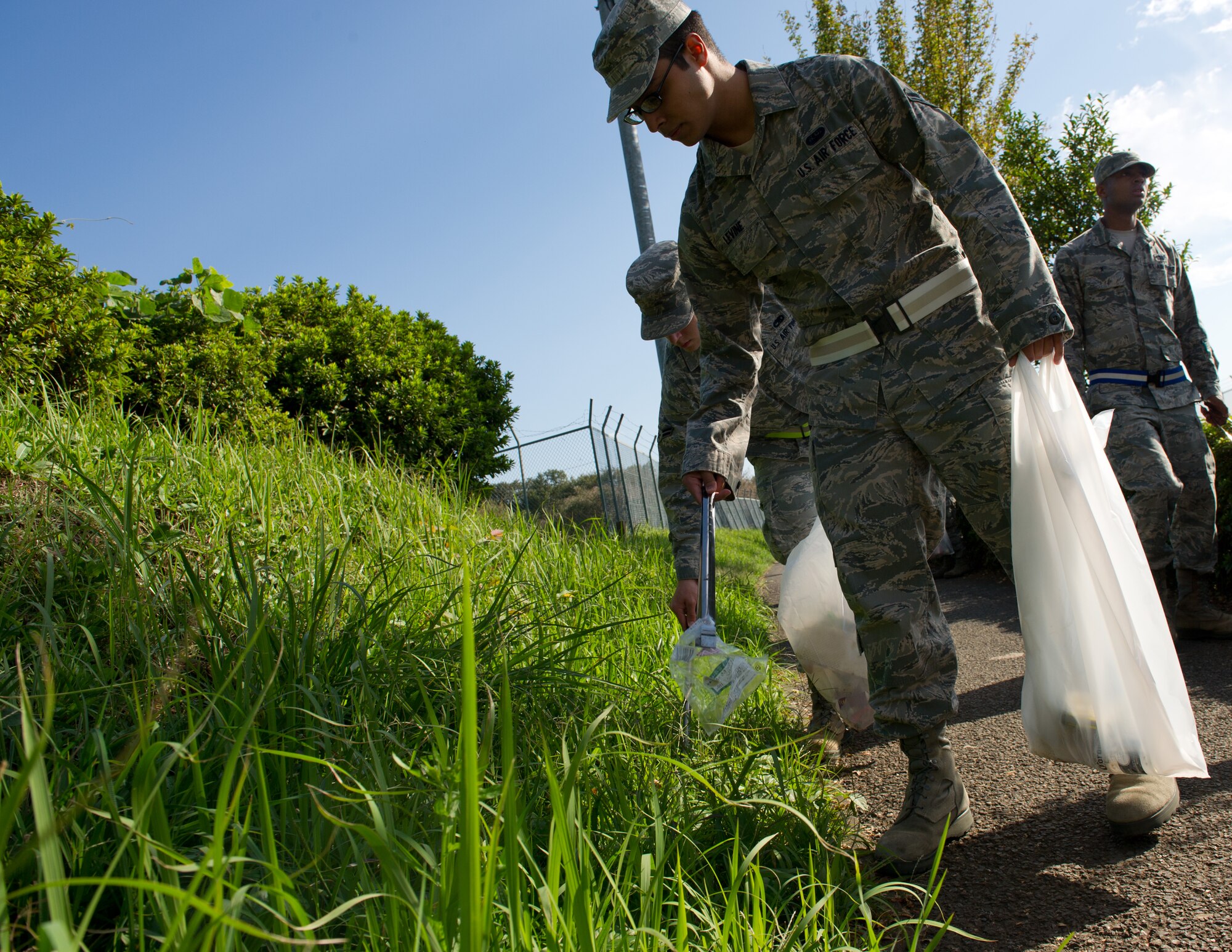 MIZUHO TOWN, Japan -- Airman 1st Class Justin Levine, 374th Communications Squadron network administration technician, picks up a piece of trash along the sidewalk at Mizuho, Japan, Oct. 11, 2012. Every month, volunteers around base help the local community by picking up bottles, cans, cigarette butts and other assorted garbage along the walkways, roads and parking lots of Mizuho. (U.S. Air Force photo by Senior Airman Andrea Salazar)