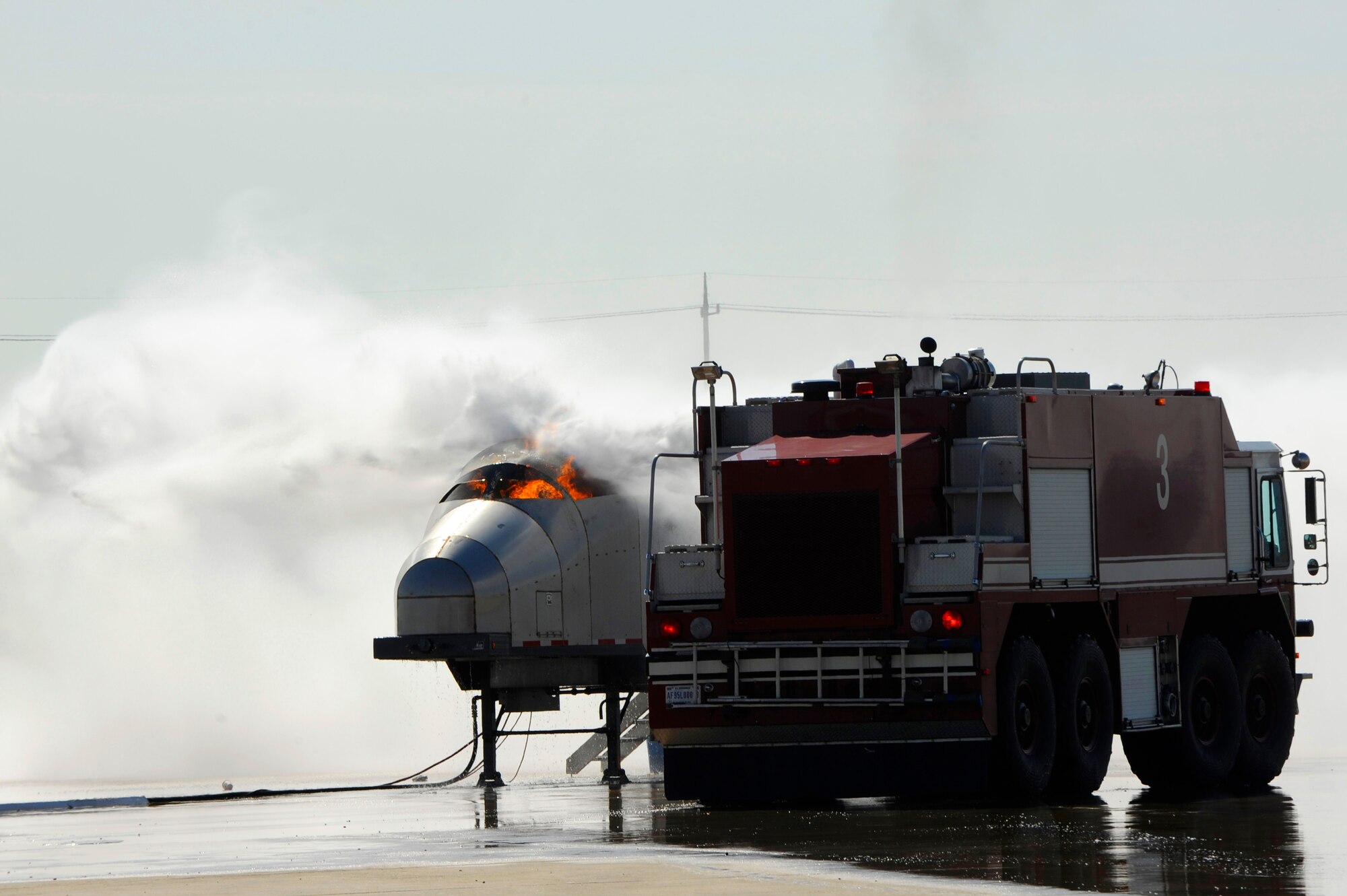 Members of 8th Fighter Wing leadership put out a fire on an aircraft fire trainer using a crash response vehicle during fire safety week at Kunsan Air Base, Republic of Korea, Oct. 12, 2012. The officers were able to experience how to operate the boom and effectively extinguish the flames. (U.S. Air Force photo/Senior Airman Marcus Morris)