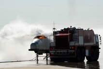 Members of 8th Fighter Wing leadership put out a fire on an aircraft fire trainer using a crash response vehicle during fire safety week at Kunsan Air Base, Republic of Korea, Oct. 12, 2012. The officers were able to experience how to operate the boom and effectively extinguish the flames. (U.S. Air Force photo/Senior Airman Marcus Morris)