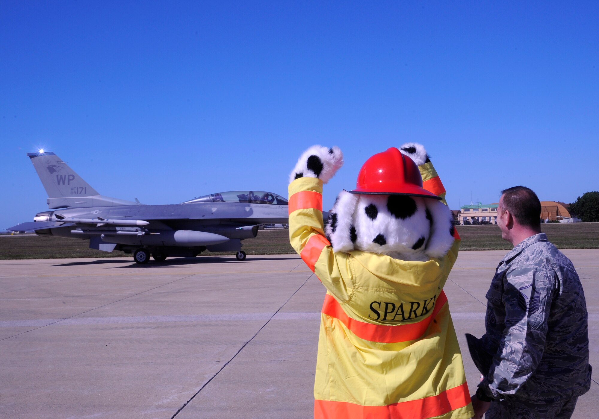 Sparky, 8th Civil Engineer Squadron firefighter’s mascot, gives the “crush ‘em” sign as he sends off a Juvat pilot in an F-16 Fighting Falcon at Kunsan Air Base, Republic of Korea, Oct. 11, 2012. The firefighters work extensively with the F-16s and train quarterly on how to power down an aircraft and open the canopy in case of a fire. (U.S. Air Force photo/Senior Airman Marcus Morris)