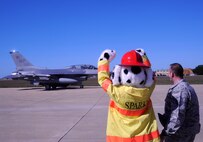 Sparky, 8th Civil Engineer Squadron firefighter’s mascot, gives the “crush ‘em” sign as he sends off a Juvat pilot in an F-16 Fighting Falcon at Kunsan Air Base, Republic of Korea, Oct. 11, 2012. The firefighters work extensively with the F-16s and train quarterly on how to power down an aircraft and open the canopy in case of a fire. (U.S. Air Force photo/Senior Airman Marcus Morris)