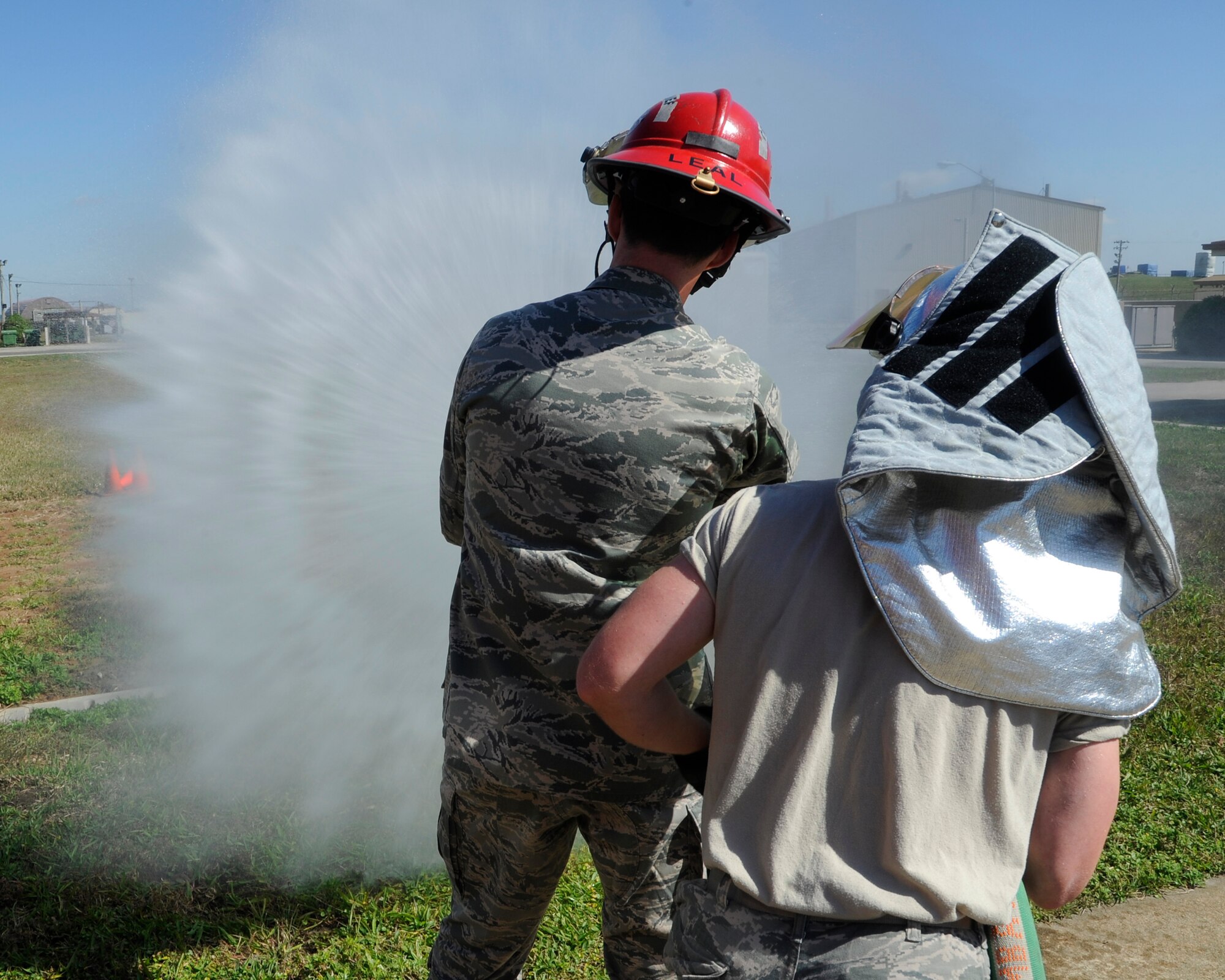 Airman First Class Jayden Steier, right, 8th Civil Engineer Squadron firefighter, teaches Capt. Jon Ackley, 8th Fighter Wing legal officer how to use a fire hose during fire safety week at Kunsan Air Base, Republic of Korea, Oct. 11, 2012. The stream from the hose can reach up to 75 feet to put out a fire. (U.S. Air Force photo/Senior Airman Marcus Morris)
