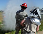 Airman First Class Jayden Steier, right, 8th Civil Engineer Squadron firefighter, teaches Capt. Jon Ackley, 8th Fighter Wing legal officer how to use a fire hose during fire safety week at Kunsan Air Base, Republic of Korea, Oct. 11, 2012. The stream from the hose can reach up to 75 feet to put out a fire. (U.S. Air Force photo/Senior Airman Marcus Morris)