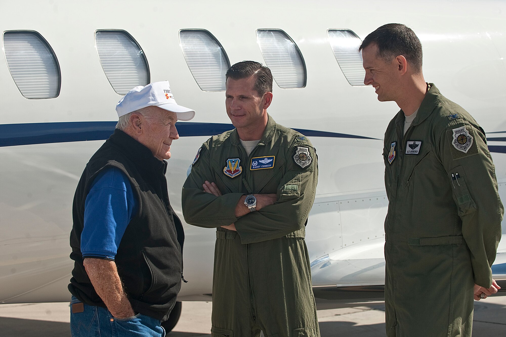 Col. Barry Cornish, 99th Air Base Wing commander, and Col. Alex Grynkewich, 57th Wing vice commander, greet retired United States Air Force Brig. Gen. Chuck Yeager upon his arrival Oct. 13, 2012, at Nellis Air Force Base, Nev. Yeager was the first person to pilot an aircraft faster than the speed of sound Oct. 14, 1947, and he broke the sound barrier again at the age of 89 in an F-15D Eagle from the 65th Aggressor Squadron. (U.S. Air Force photo by Staff Sgt. Christopher Hubenthal)