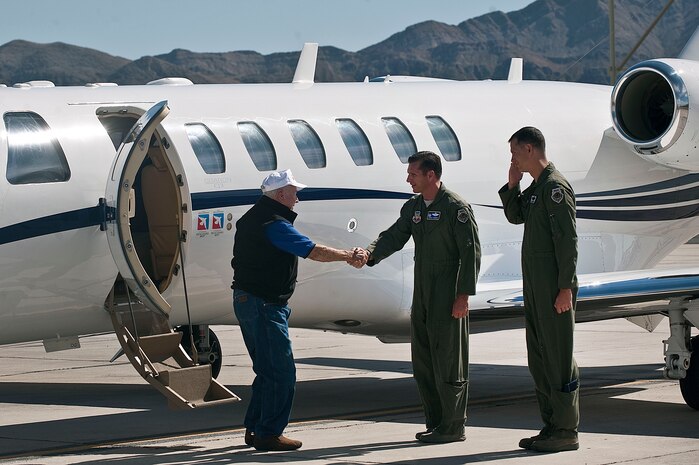Col. Barry Cornish, 99th Air Base Wing commander, and Col. Alex Grynkewich, 57th Wing vice commander, greet retired United States Air Force Brig. Gen. Chuck Yeager upon his arrival Oct. 13, 2012, at Nellis Air Force Base, Nev. Yeager was the first person to pilot an aircraft faster than the speed of sound Oct. 14, 1947. He broke the sound barrier again at the age of 89 in a 65th Aggressor Squadron F-15D Eagle. (U.S. Air Force photo by Staff Sgt. Christopher Hubenthal)