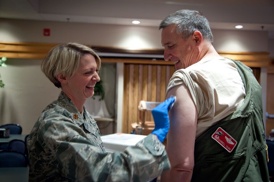 Col. Darrell Young, Commander of the 934th Airlift Wing, is given his flu shot by Maj. Alexis Stucki, 934th Aeromedical Evacuation Squadron.   Leadership of the 934 AW lined up to get their annual flu vaccines before the pre-Unit Training Assembly meeting Thursday evening at the Minneapolis-St. Paul Air Reserve Station, Minn.  (U.S. Air Force Photo/Shannon McKay)