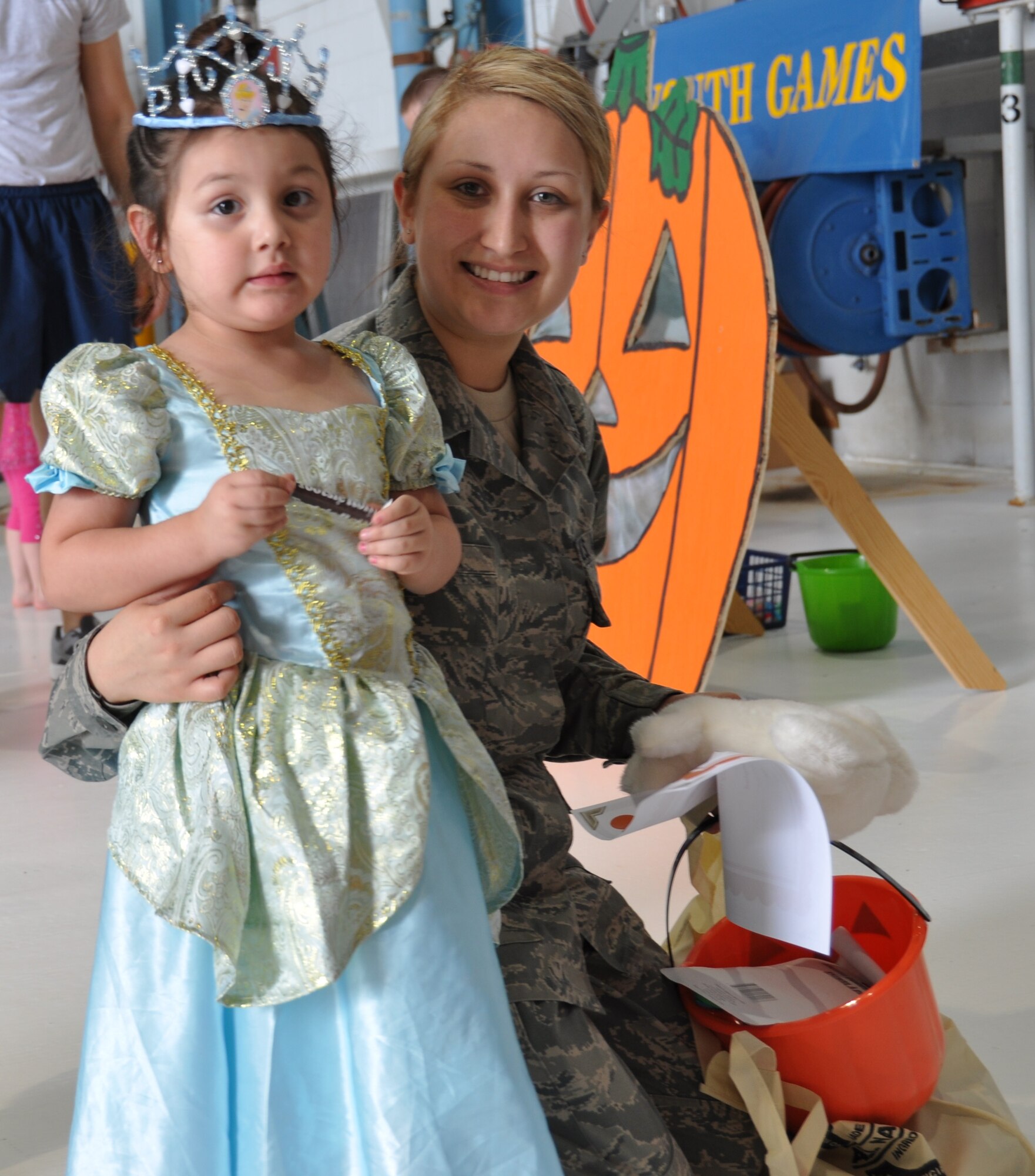 Airman 1st Class Christine Narro, 433rd Medical Squadron,takes a moment from trick or treating with her daughter, Amaretta at the 433rd Airlift Wing Family Day festivities on Oct. 13, 2012 at Joint Base San Antonio-Lackland, Texas. A car show, motorcycle ride, Halloween costume contest and Commander's Tricycycle Race were among the other activities for Airmen and their families to enjoy.
