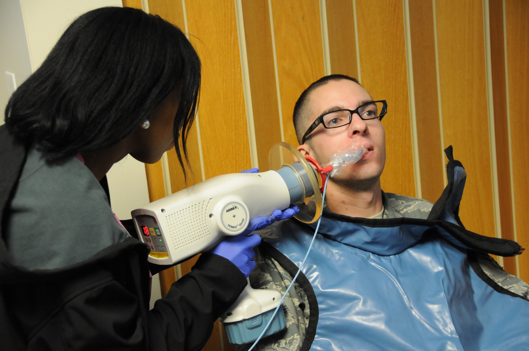 Marie Edouard, Logistics Health dental assistant, uses a portable X-ray machine to take a dental X-ray of Senior Airman Chris Winship, 267th Combat Communications Squadron cyber transport technician, at the 102nd Medical Group building on Otis Air National Guard Base, Mass. Oct. 13. Winship was one of approximately 120 servicemembers who received complimentary dental treatment from Logistics Health dental professionals thorughout the weekend. (Air National Guard photo by Senior Airman Patrick McKenna/Released)