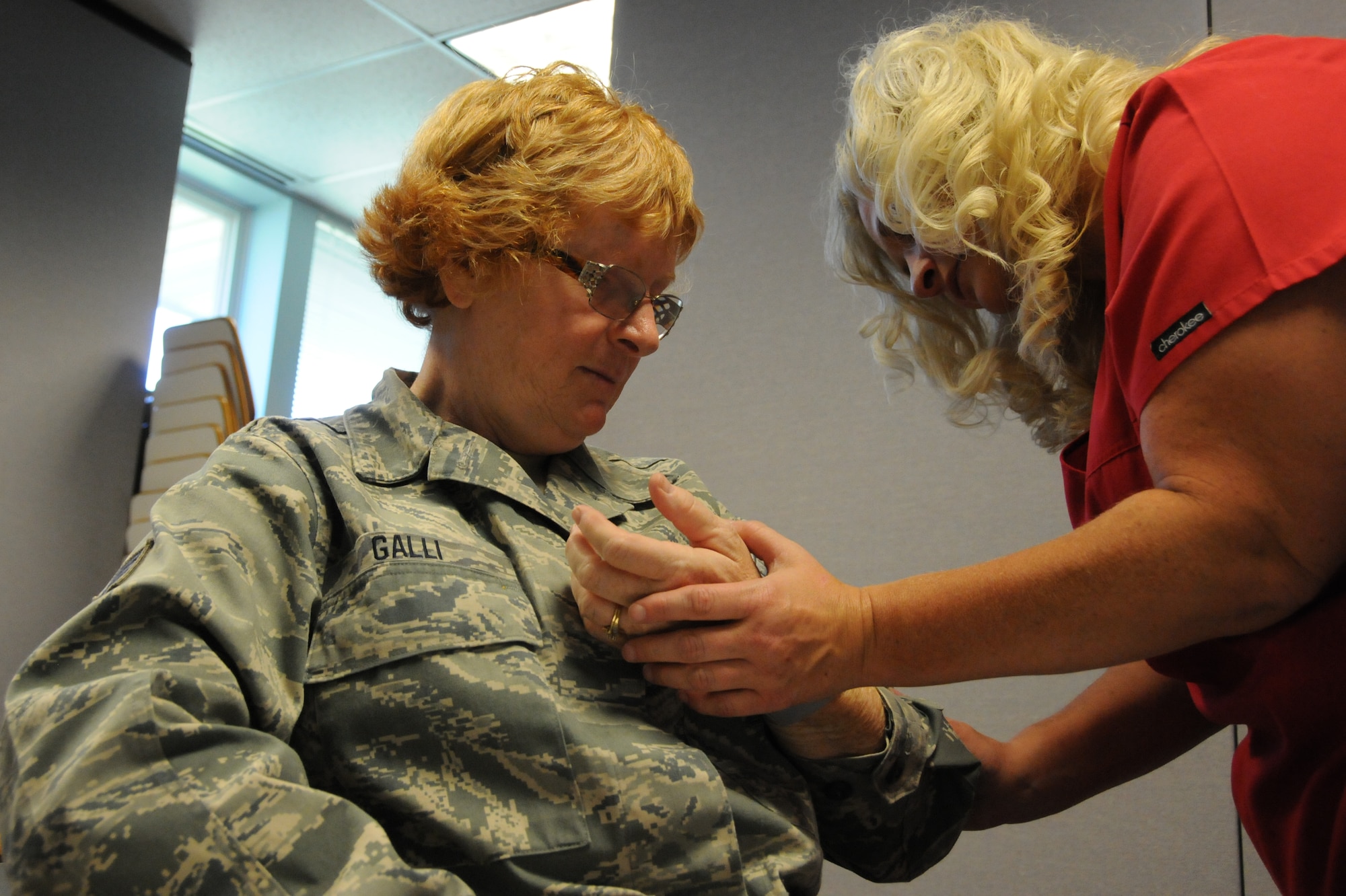 Staff Sgt. Doris Galli, 102nd Force Support Flight cook, watches as Shelley Fleetwood, Logistics Health team lead, checks her blood pressure prior to a dental exam at the 102nd Medical Group building on Otis Air National Guard Base, Mass. Oct. 13. Galli was one of approximately 120 servicemembers who received complimentary dental treatment from Logistics Health dental professionals thorughout the weekend. (National Guard photo by Senior Airman Patrick McKenna/Released)