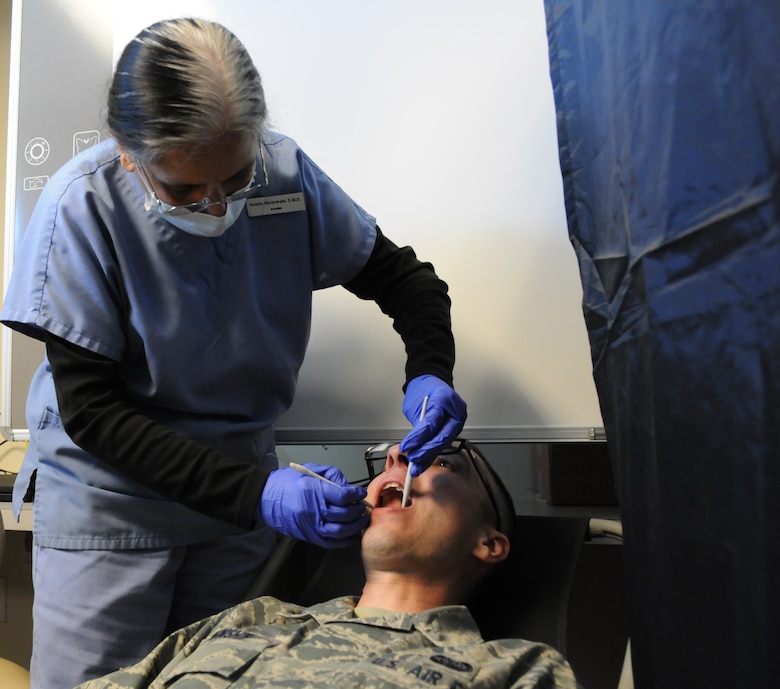 Dr. Rekha Hariawala, Logistics Health dentist, performs a dental exam on Senior Airman Chris Winship, 267th Combat Communications Squadron cyber transport technician, at the 102nd Medical Group building on Otis Air National Guard Base, Mass. Oct. 13. Winship was one of approximately 120 servicemembers who received complimentary dental treatment from Logistics Health dental professionals thorughout the weekend. (Air National Guard photo by Senior Airman Patrick McKenna/Released)