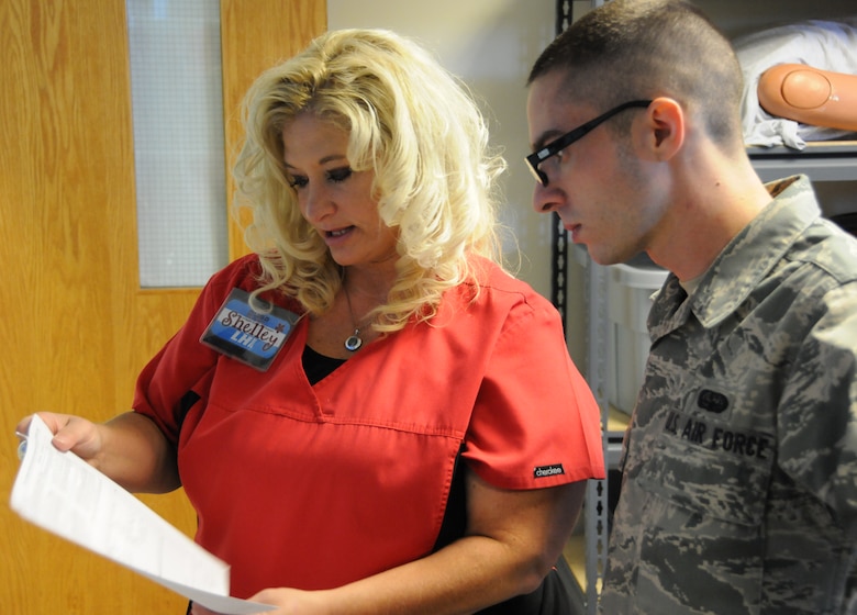 Shelley Fleetwood, Logistics Health team lead, explains to Senior Airman Chris Winship, 267th Combat Communications Squadron cyber transport technician, how to fill out his medical paperwork prior to his examination at the 102nd Medical Group building on Otis Air National Guard Base, Mass. Oct. 13-14. The Logistics Health dental team treated approximately 120 servicemembers throughout the weekend. (Air National Guard photo by Senior Airman Patrick McKenna/Released)