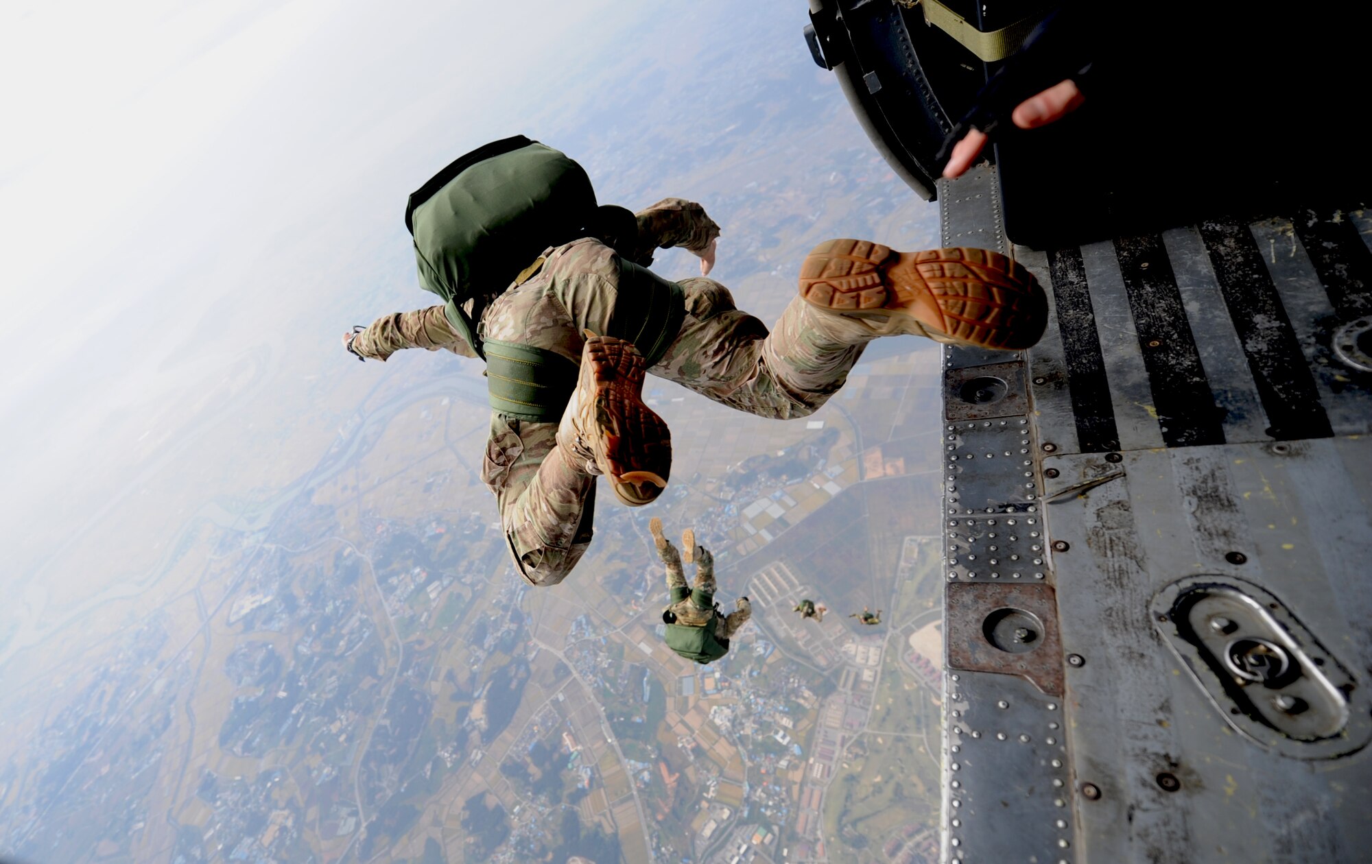 A 31st Rescue Squadron pararescueman freefalls with a parachute after jumping from a 33rd Rescue Squadron HH-60 Pave Hawk during training scenarios for Exercise Pacific Thunder 2012 at Osan Air Base, Republic of Korea, Oct. 12, 2012. Pacific Thunder is an annual two-week exercise that members of the 31st and 33rd Rescue Squadrons link up with the 25th Fighter Squadron and other units at Osan AB, to test combat search and rescue tactics to prepare for real-world emergencies. (U.S. Air Force photo/Staff Sgt. Sara Csurilla)