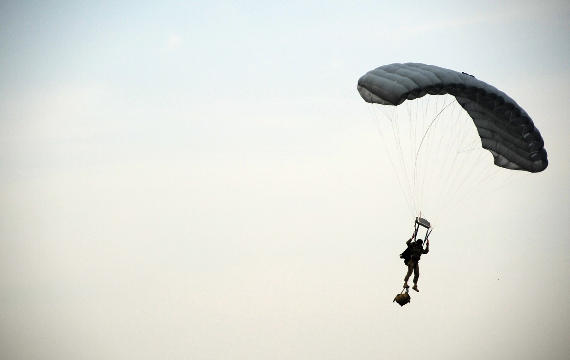 A 31st Rescue Squadron pararescueman decends with a parachute after jumping from a 33rd Rescue Squadron HH-60 Pave Hawk during training scenarios for Pacific Thunder 2012 at Osan Air Base, Republic of Korea, Oct. 12, 2012. Pacific Thunder is an annual two-week exercise that links up 31st and 33rd Rescue Squadron Airmen with the 25th Fighter Squadron and other units at Osan AB, to test combat search and rescue tactics to prepare for real-world emergencies. (U.S. Air Force photo/Staff Sgt. Sara Csurilla)
