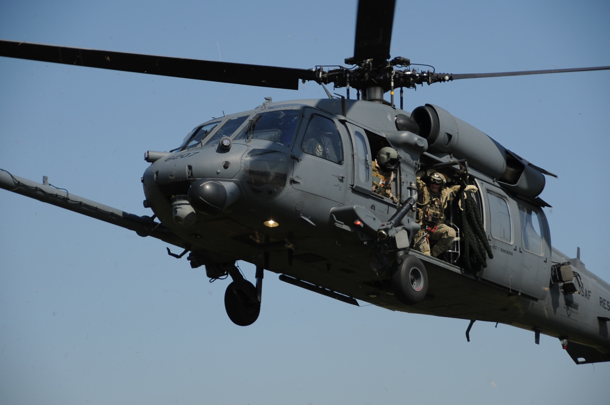 A 31st Rescue Squadron pararescueman leans out of the door of a 33rd Rescue Squadron HH-60 Pave Hawk during a combat search and rescue training scenario for Pacific Thunder at Osan Air Base, Republic of Korea, Oct. 12, 2012. Pacific Thunder is an annual two-week exercise where members of the 31st and 33rd Rescue Squadrons met up with the 25th Fighter Squadron and other units at Osan AB, to test CSAR tactics to prepare for real-world emergencies. (U.S. Air Force photo/Staff Sgt. Sara Csurilla)