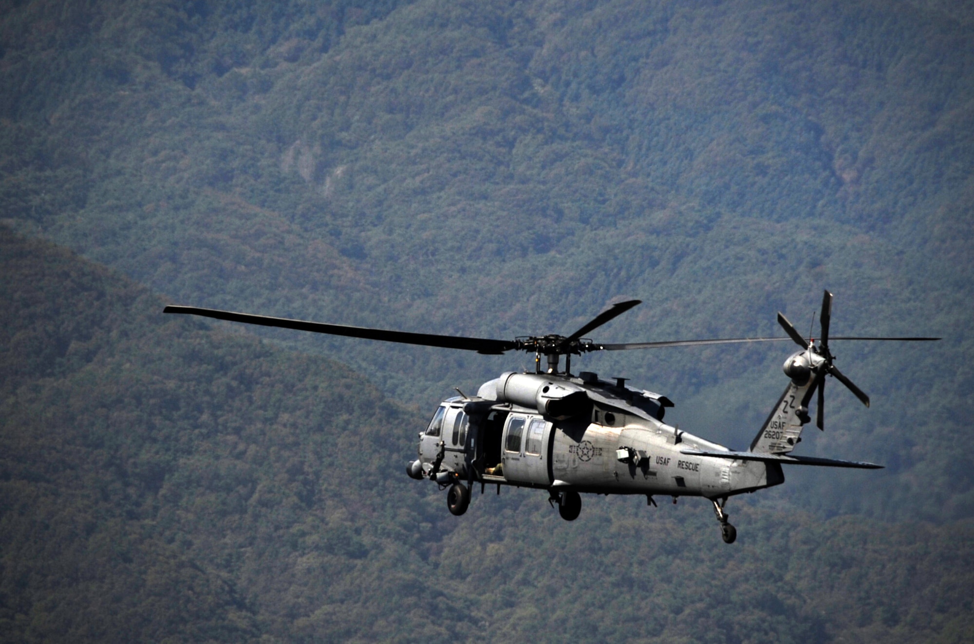 A 33rd Rescue Squadron HH-60 Pave Hawk flies through mountains near Osan Air Base, Republic of Korea, to kick off the first day of Exercise Pacific Thunder 2012 during a combat search and rescue training mission at Osan AB, Oct. 12, 2012. Pacific Thunder is an annual two-week exercise where members of the 33rd and 31st Rescue Squadrons met up with the 25th Fighter Squadron and multiple other units at Osan AB, to test CSAR tactics to prepare for real-world emergency situations. (U.S. Air Force photo/Staff Sgt. Sara Csurilla)
