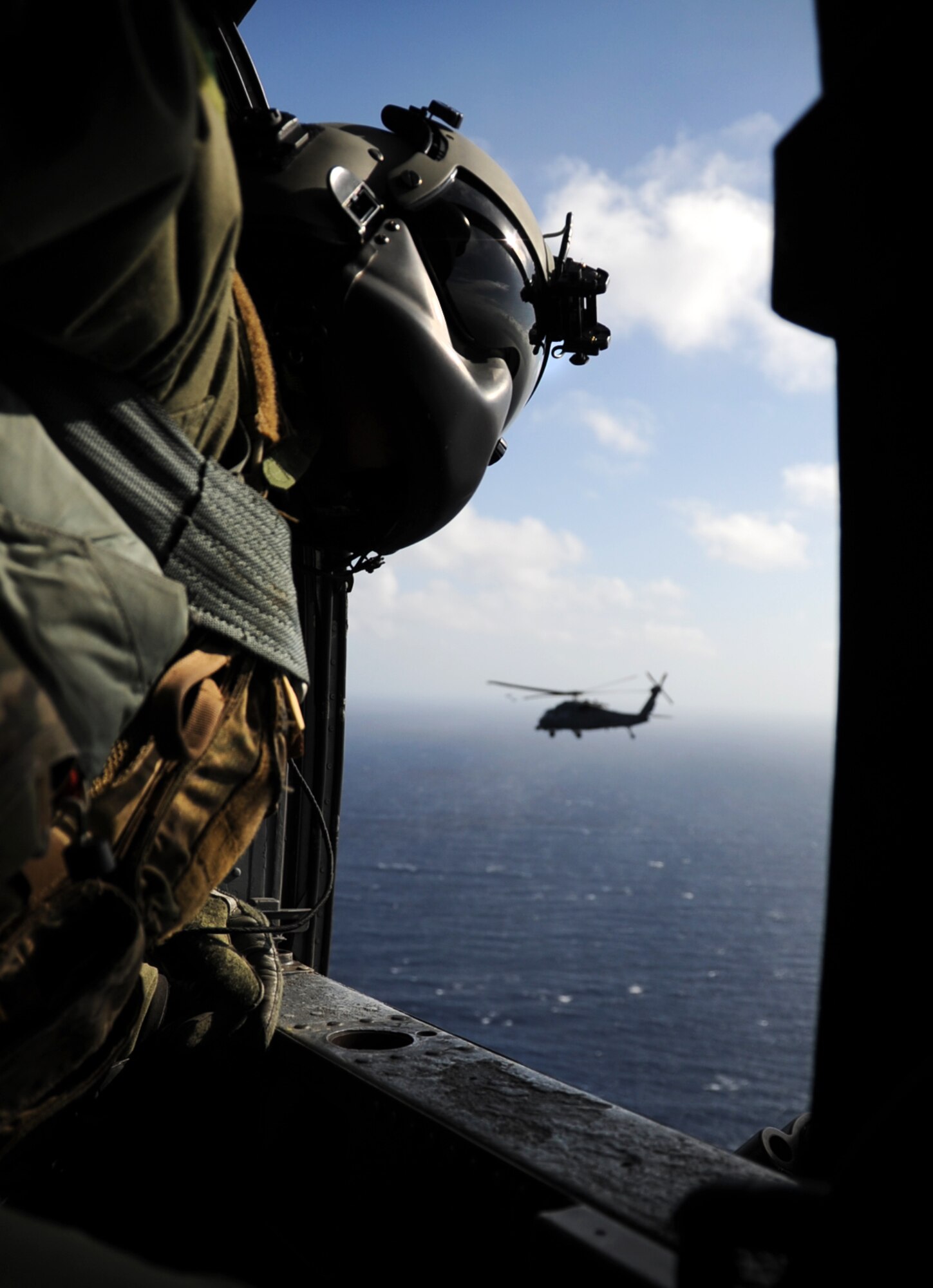 A flight engineer with the 33rd Rescue Squadron looks through his window on an HH-60 Pave Hawk while traveling from Kadena Air Base, Japan, to Osan Air Base, Republic of Korea, Oct. 10, 2012. The 31st and 33rd RQSs traveled to Osan to team up with the 25th Fighter Squadron to participate in Pacific Thunder 2012. Pacific Thunder is an annual two-week exercise at Osan AB to test combat search and rescue tactics to prepare for real-world emergencies. (U.S. Air Force photo/Staff Sgt. Sara Csurilla)