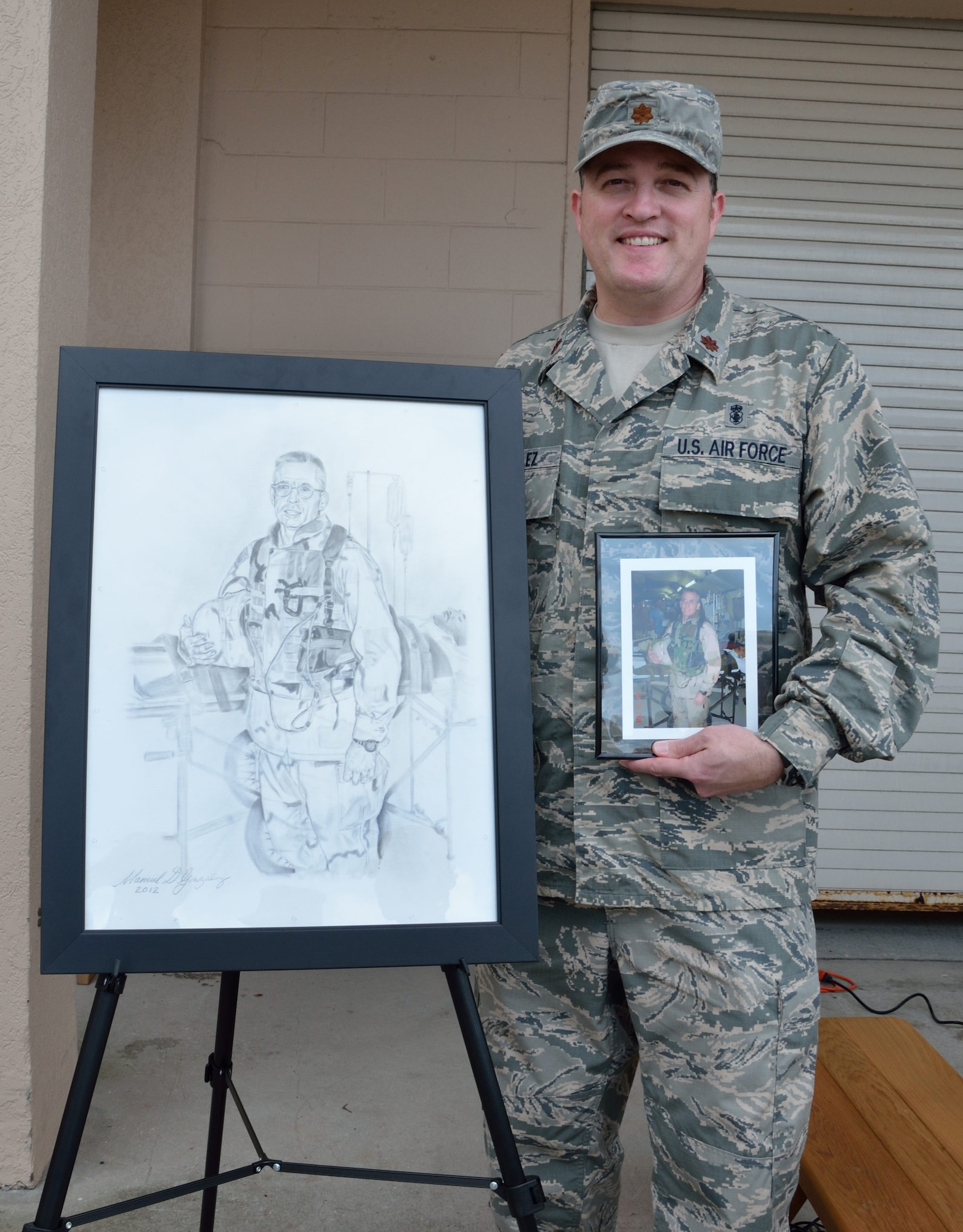 Maj. Manuel Gonzalez stands next to the sketch he made in memory of Maj. Kevin Wilkins Oct. 14, 2012 at Patrick Air Force Base, Fla. Wilkins, a 920th Aeromedical Staging Squadron critical care nurse, died from a brain tumor in 2008. (U.S. Air Force photo/Staff Sgt. Anna-Marie Wyant)