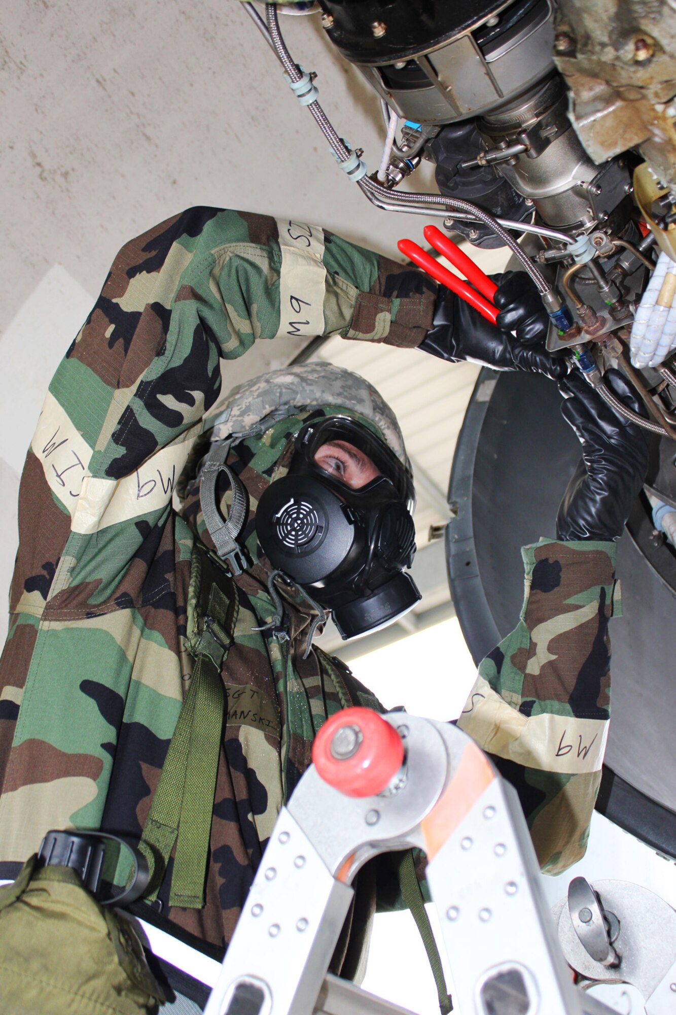 Staff Sgt. Jason Klemanski, 127th Maintenance Support Squadron, works on an A-10 Thunderbolt II engine while he wears chemical protective gear, Oct. 13, 2012, at Selfridge Air National Guard Base, Mich. The squadron spent most of a day wearing the gear while performing their duties around the aircraft. (Air National Guard photo by TSgt. Dan Heaton)
