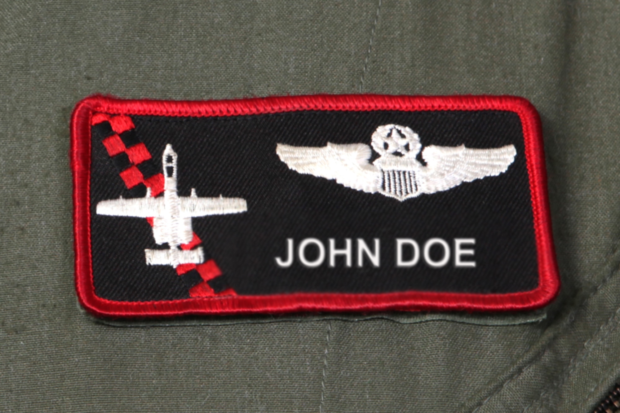 The name tag worn by a pilot of the 107th Fighter Squadron is seen in this photo illustration. This particular pilot is rated as a command pilot, as indicated by the wings above the name. A command pilot rating signifies having served at least 15 years as a rated pilot with at least 3,000 hours of total flight time. The patch also includes an outline of an A-10 Thunderbolt II, the type of aircraft operated by the 107th. The name of the pilot on this patch has been electronically altered for security purposes. (Air National Guard photo illustration by Brittani Baisden)