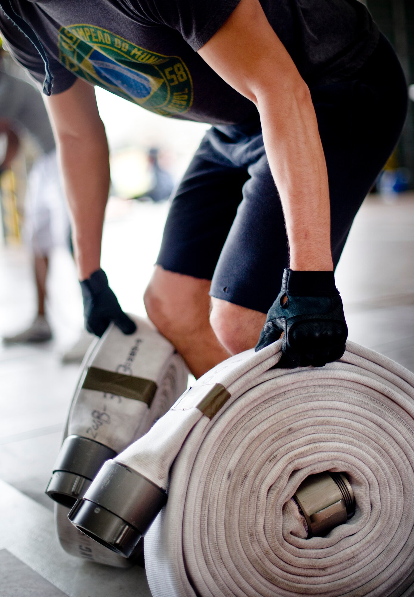 YOKOTA AIR BASE, Japan -- A member from Yokota Air Base, Japan prepares to lift two fire hoses during the equipment carry part of the Fire Prevention Week Fire Muster Competition at Yokota Air Base, Japan, Oct. 12, 2012. Fire Prevention Week is an annual event which not only promotes fire safety, but also honors the sacrifices of firefighters throughout the U.S. and abroad. (U.S. Air Force photo by Staff Sgt. Stacy Moless)     