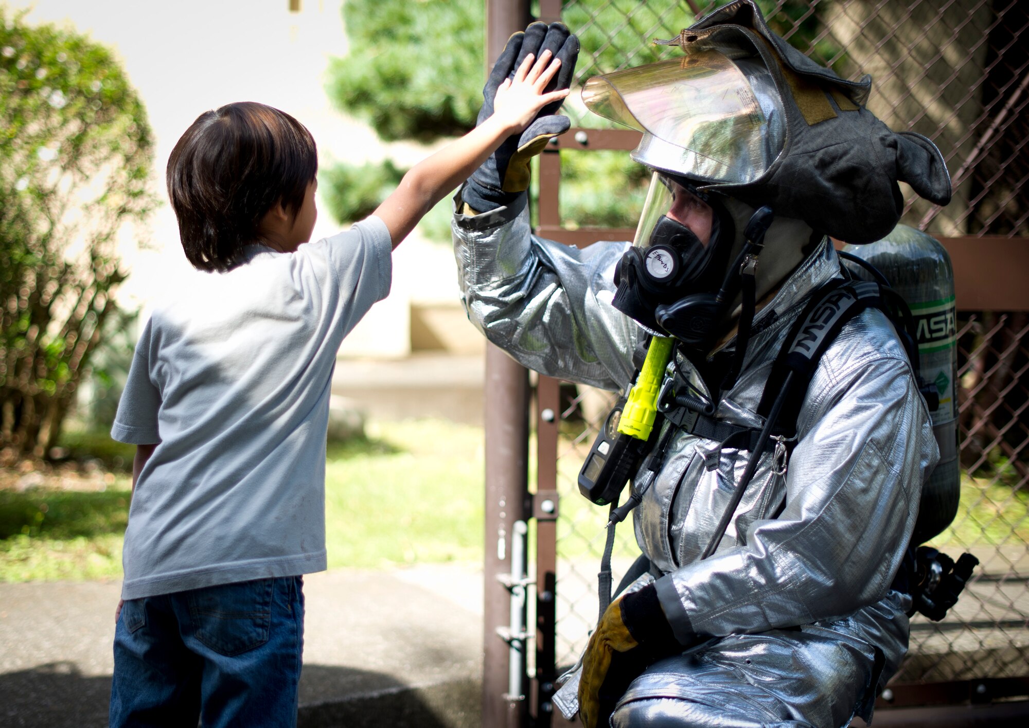 YOKOTA AIR BASE, Japan -- A child from Joan K. Mendel elementary gives a high-five to Airman 1st Class Daniel Edwards, 374th Civil Engineer Squadron firefighter, at Yokota Air Base, Japan Oct. 10, 2012. Firefighters visited the schools to talk to children about fire safety as well as what to do during a fire emergency. (U.S. Air Force photo by Staff Sgt. Stacy Moless) 