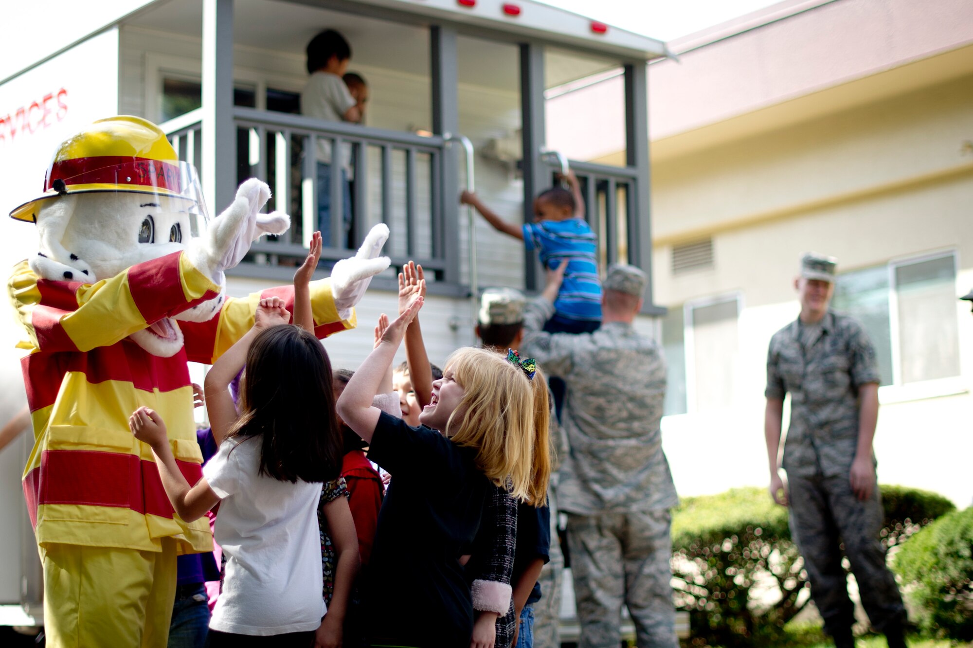 YOKOTA AIR BASE, Japan -- Children from Joan K. Mendel Elementary School get a high-five from Sparky the Fire Dog after completing the smoke house at Yokota Air Base, Japan Oct. 10, 2012. The theme for this year is "Have Two Ways Out!" to encourage families to plan fire escape routes and practice getting out safely. (U.S. Air Force photo by Staff Sgt. Stacy Moless) 