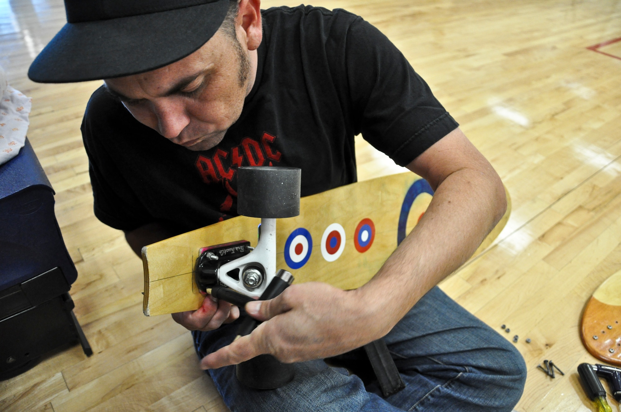 BUCKLEY AIR FORCE BASE, Colo. – Aaron Mikeulich, Knights of the Air creative director, works on a longboard during an event at the Buckley Fitness Center Oct. 12, 2012. KotA teamed up with the base outdoor recreation to provide affordable longboards to Team Buckley. KotA, a Denver-based organization created by two military veterans, provides hands on demonstrations at military bases in Colorado. (U.S. Air Force photo by Staff Sgt. Nicholas Rau) 