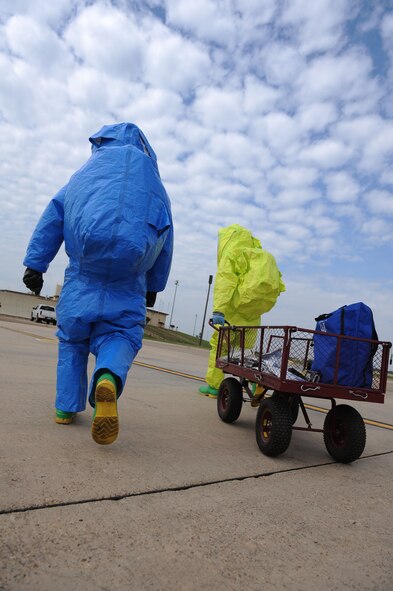 Staff Sgt. Shawn Gallagher, left, 2nd Aerospace Medicine Squadron bioenvironmental engineer technician, and Airman 1st Class Brian Foley, 2nd Civil Engineer Squadron emergency management, approach the Warrior Center during a major accident response exercise on Barksdale Air Force Base, La., Oct. 12. The Airmen donned hazardous material suits to test the building for contaminates. Firefighters, security forces, emergency management, bioenvironmental and medical Airmen and civilians worked together to reduce the spread of the hazardous substance. (U.S. Air Force photo/ Senior Airman Micaiah Anthony)(RELEASED)