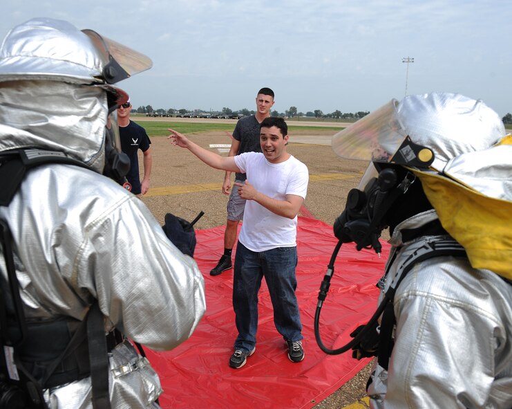 Airmen exposed to a simulated hazardous substance explain how they were contaminated to firefighters from the 2nd Civil Engineer Squadron during a major accident response exercise on Barksdale Air Force Base, La., Oct. 12. Before the Airmen could proceed through the decontamination area, firefighters had to hose them down with water and quarantine them until paramedics arrived. While in quarantine, Airmen told the rescuers they were exposed to a white powdery substance in the Warrior Center's dining facility. (U.S. Air Force photo/ Senior Airman Micaiah Anthony)(RELEASED)
