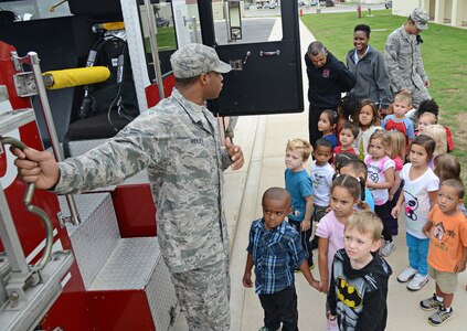 Airman 1st Class Marcell Ridley, 902nd Fire Emergency Services firefighter, teaches pre-school students at the child development center about a fire truck Oct. 9 at Joint Base San Antonio-Randolph. According to the National Archives and Records Administration's Library Information Center, Fire Prevention Week is the longest running public health and safety observance on record. The President of the United States has signed a proclamation proclaiming a national observance during that week every year since 1925. (U.S. Air Force photo by Benjamin Faske)