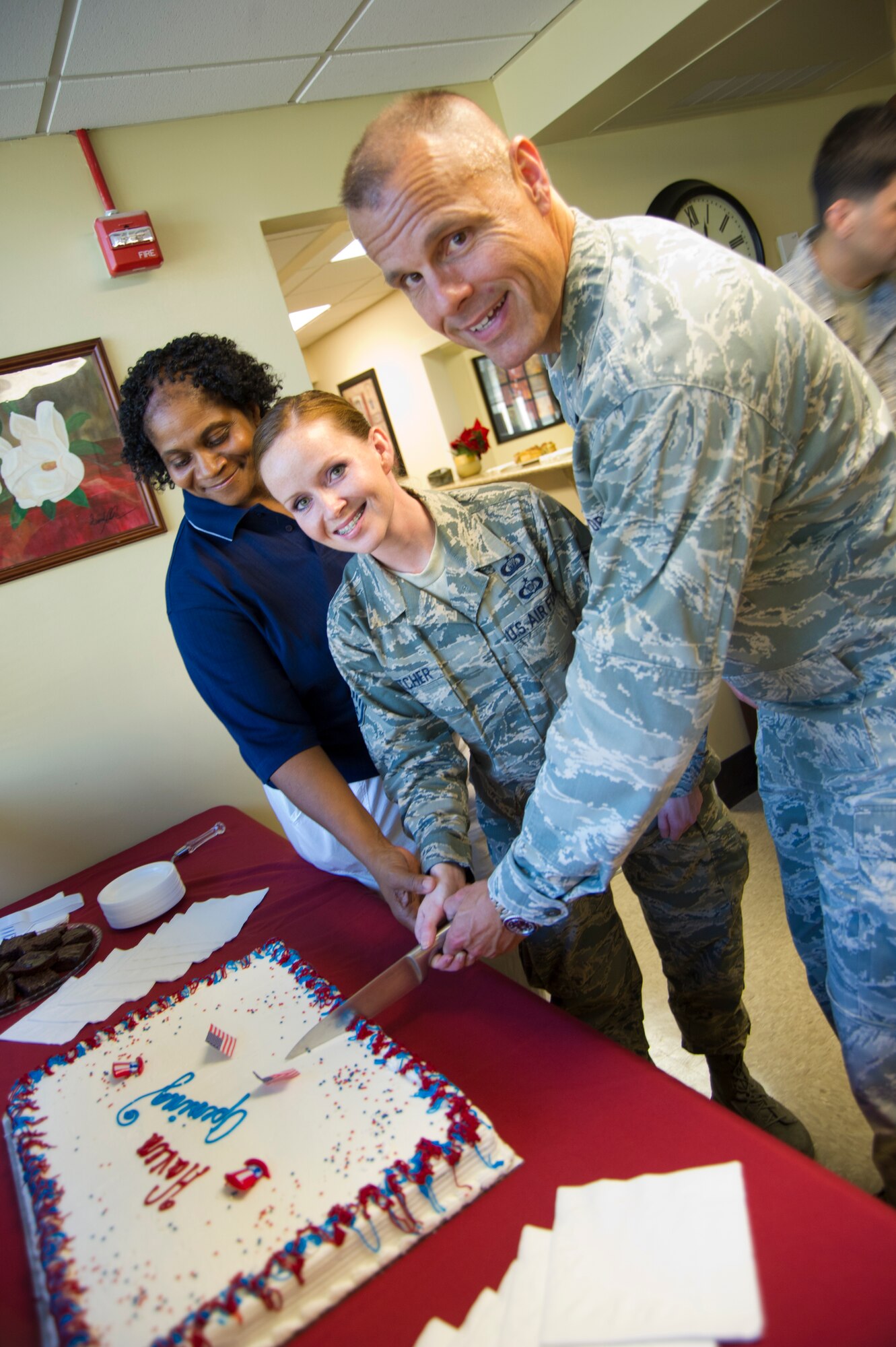 Sara Robinson, the Haven housekeeper, Staff Sgt. Tawny Crutcher, 81st Training Wing chapel assistant, and Brig. Gen. Brad Spacy, 81st TRW commander,  cut the cake during a ceremony opening the Haven in building 4908 Oct. 12, 2012, at Keesler Air Force Base, Miss.  (U.S. Air Force photo by Adam Bond)