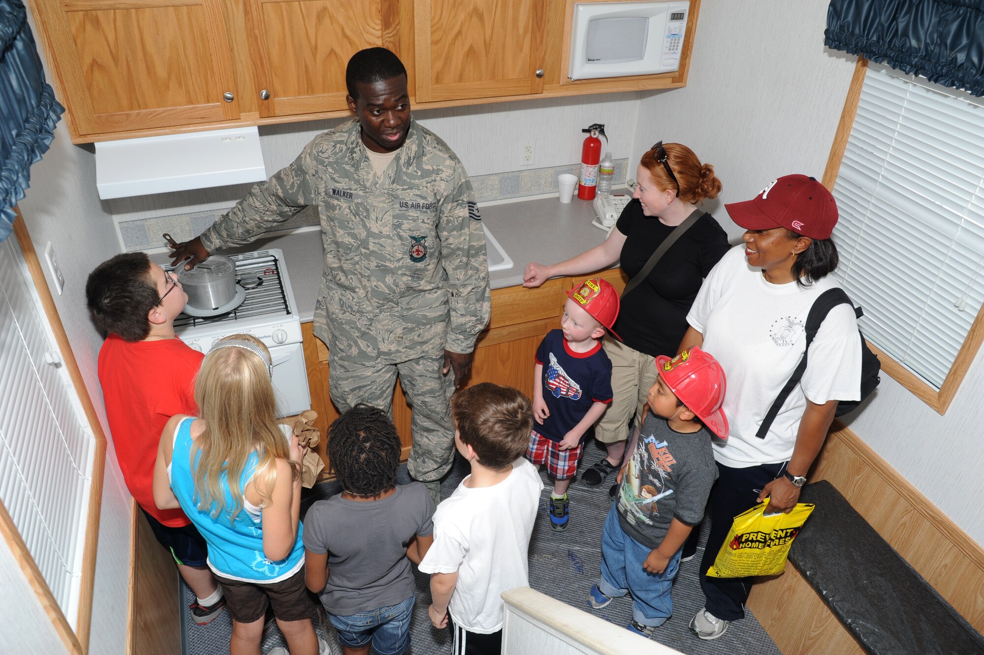 Tech. Sgt. Donald Walker, Keesler firefighter, provides a fire safety demonstration inside a fire safe house during the Keesler Fire Department’s open house Oct. 13, 2012, Keesler Air Force Base, Miss.  The event was held on the final day of fire prevention week during which the fire department conducted random fire drills throughout the base, toured various facilities with Sparky the Fire Dog, passed out fire safety handouts and fire hats for children and provided stove and fire extinguisher demonstrations.  (U.S. Air Force photo by Kemberly Groue)