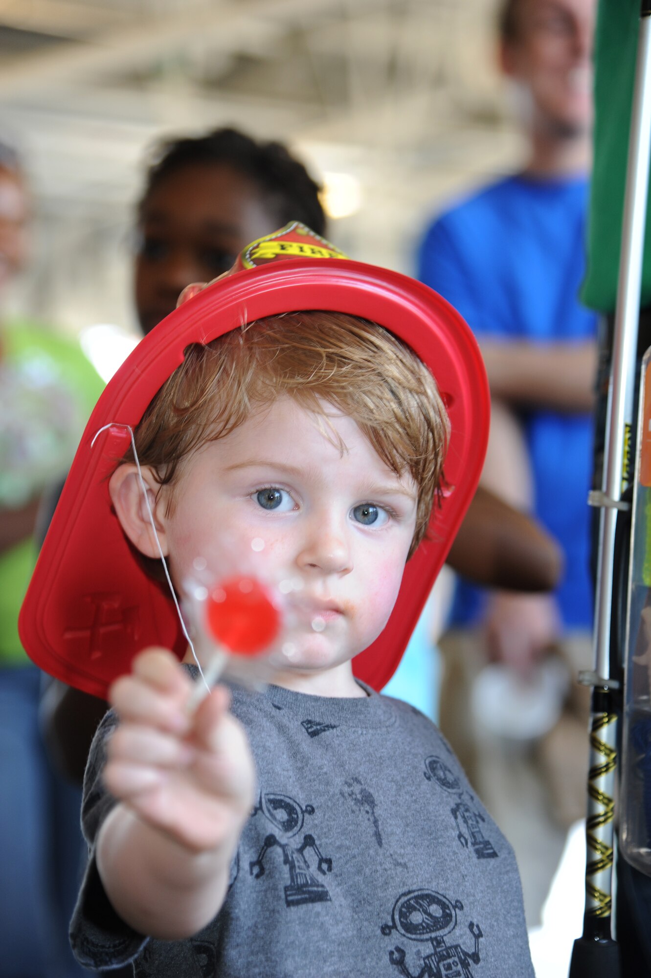 Two-year-old Noble Gagnon, son of Tech. Sgt. Geoffrey Gagnon, 81st Training Support Squadron, and Staff Sgt. Christina Gagnon, 81st Medical Group, displays his lollipop while wearing a firefighter hat during the Keesler Fire Department’s open house Oct. 13, 2012, Keesler Air Force Base, Miss.  The event was held on the final day of fire prevention week during which the fire department conducted random fire drills throughout the base, toured various facilities with Sparky the Fire Dog, passed out fire safety handouts and fire hats for children and provided stove and fire extinguisher demonstrations.  (U.S. Air Force photo by Kemberly Groue)