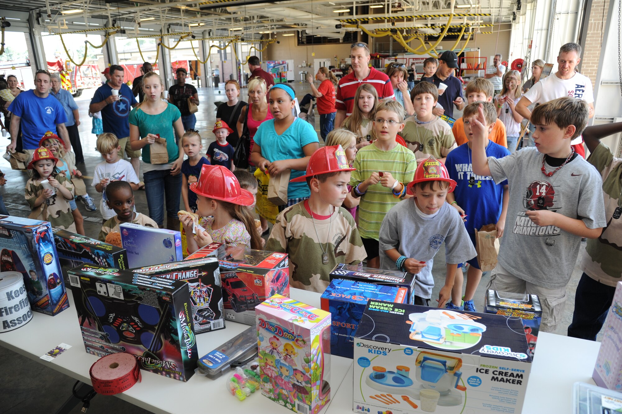 Children gather around during drawings for giveaways at the Keesler Fire Department open house which concluded a week-long fire prevention week Oct. 13, 2012, Keesler Air Force Base, Miss.  The fun-filled event included visits with Sparky the Fire Dog, free hot dogs and popcorn, fire truck static displays, fire safe house tours, games and giveaways.  (U.S. Air Force photo by Kemberly Groue)