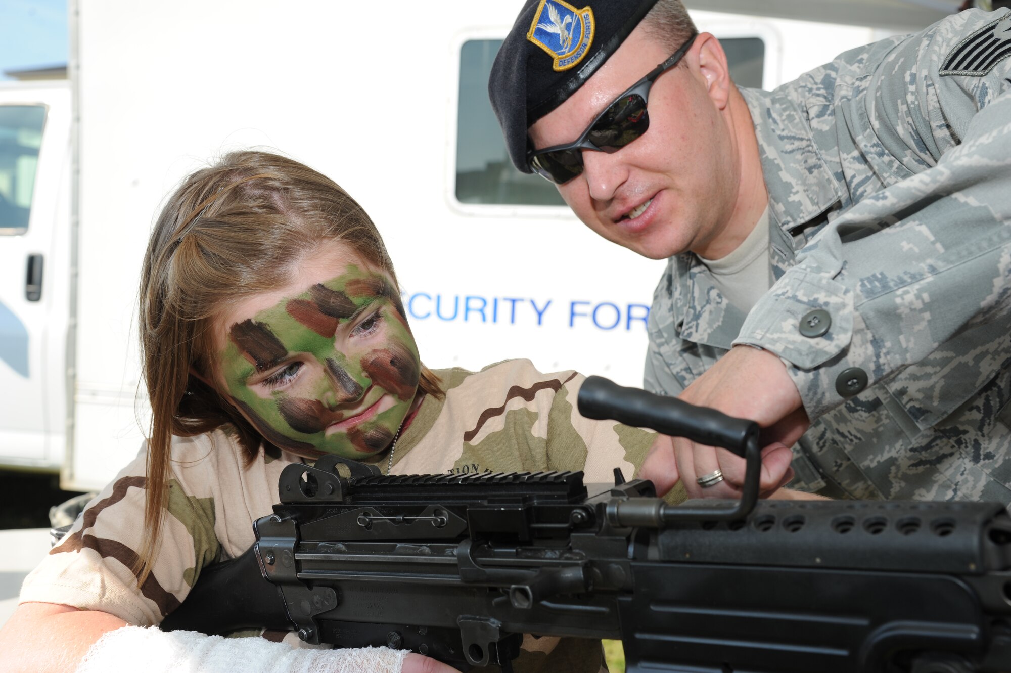 Ten-year-old Delaney Ware, daughter of Tammy Ware, St. Martin Upper Elementary receptionist, becomes familiar with an M-249 Bravo weapon by the help of Tech. Sgt. Nick Tessmer, 81st Security Forces Squadron, during Operation Hero Oct. 13, 2012, at Keesler Air Force Base, Miss.  Operation Hero is presented twice a year to give parents a chance to expose their children to what happens when they leave home for deployments tasking or on temporary duty.  The Wares were invited to the event through the school liaison office on base to educate teachers at local schools about what it is like for their military students who may go through a similar experience with their parents.  (U.S. Air Force photo by Kemberly Groue)