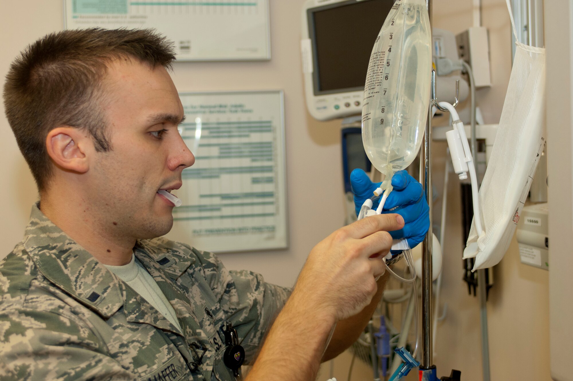 1st Lt. Travis Schaffer, 633rd Medical Operations Squadron emergency room registered nurse, prepares a bag of fluids to administer to a patient, Sept. 10, at U.S. Air Force Hospital Langley, at Langley Air Force Base, Va. Schaffer used his Air Force training and schooling to help an injured hiker while jogging at Mohican State Park, in Loudonville, Ohio. (U.S. Air Force photo by Airman 1st Class R. Alex Durbin/Released)