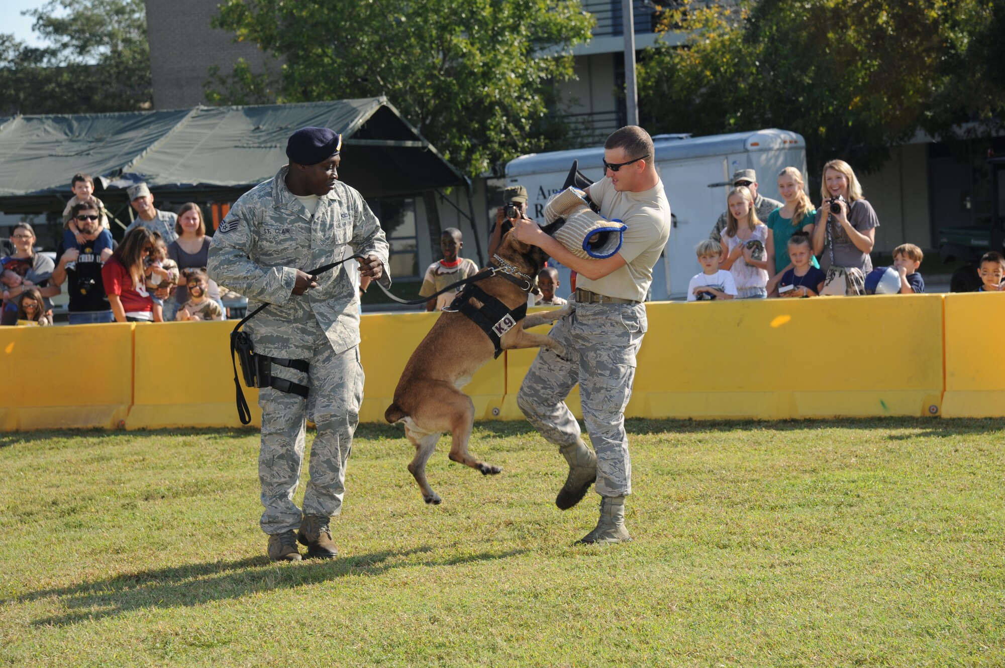 Staff Sgt. Garth St. Clair, 81st Security Forces Squadron, and his military working dog, Carlos, perform a MWD demonstration by using Staff Sgt. Javonnia Peak, 81st SFS, as a ‘bad guy’ during Operation Hero Oct. 13, 2012, at Keesler Air Force Base, Miss.  Operation Hero is presented twice a year to give parents a chance to expose their children to what happens when they leave home for deployments tasking or on temporary duty.  (U.S. Air Force photo by Kemberly Groue)