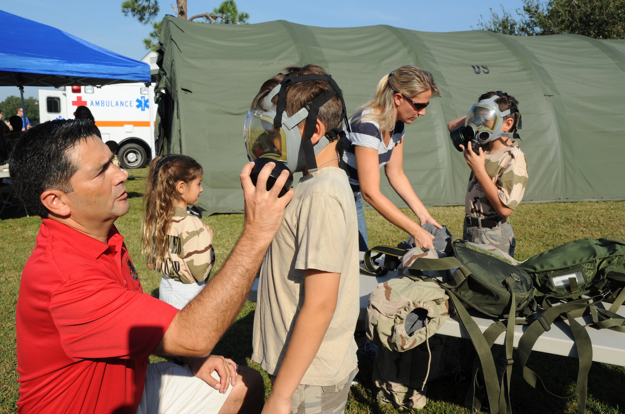Col. Rene Romero, 81st Training Wing vice commander, and his family, Elena, 7; Ben, 11; his wife, Sharmin; and Matthew, 9, tries on chemical gear during Operation Hero Oct. 13, 2012, at Keesler Air Force Base, Miss.  Operation Hero is presented twice a year to give parents a chance to expose their children to what happens when they leave home for deployments tasking or on temporary duty.  (U.S. Air Force photo by Kemberly Groue)