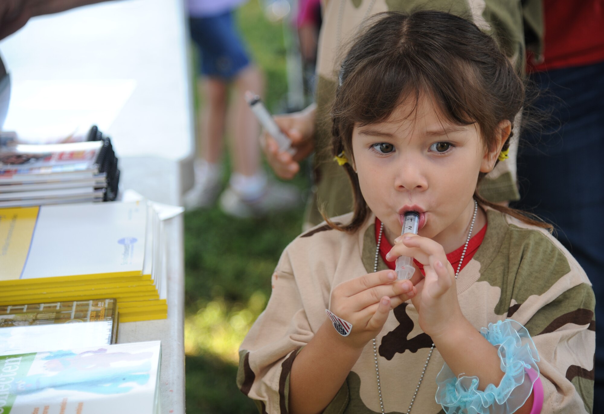 Four-year-old Bella Stevenson, daughter of Staff Sgt. Sally Stevenson, 81st Medical Support Squadron, drinks juice through a plastic medicine syringe which simulates medical shots at Operation Hero Oct. 13, 2012, at Keesler Air Force Base, Miss.  Operation Hero is presented twice a year to give parents a chance to expose their children to what happens when they leave home for deployments tasking or on temporary duty.  (U.S. Air Force photo by Kemberly Groue)