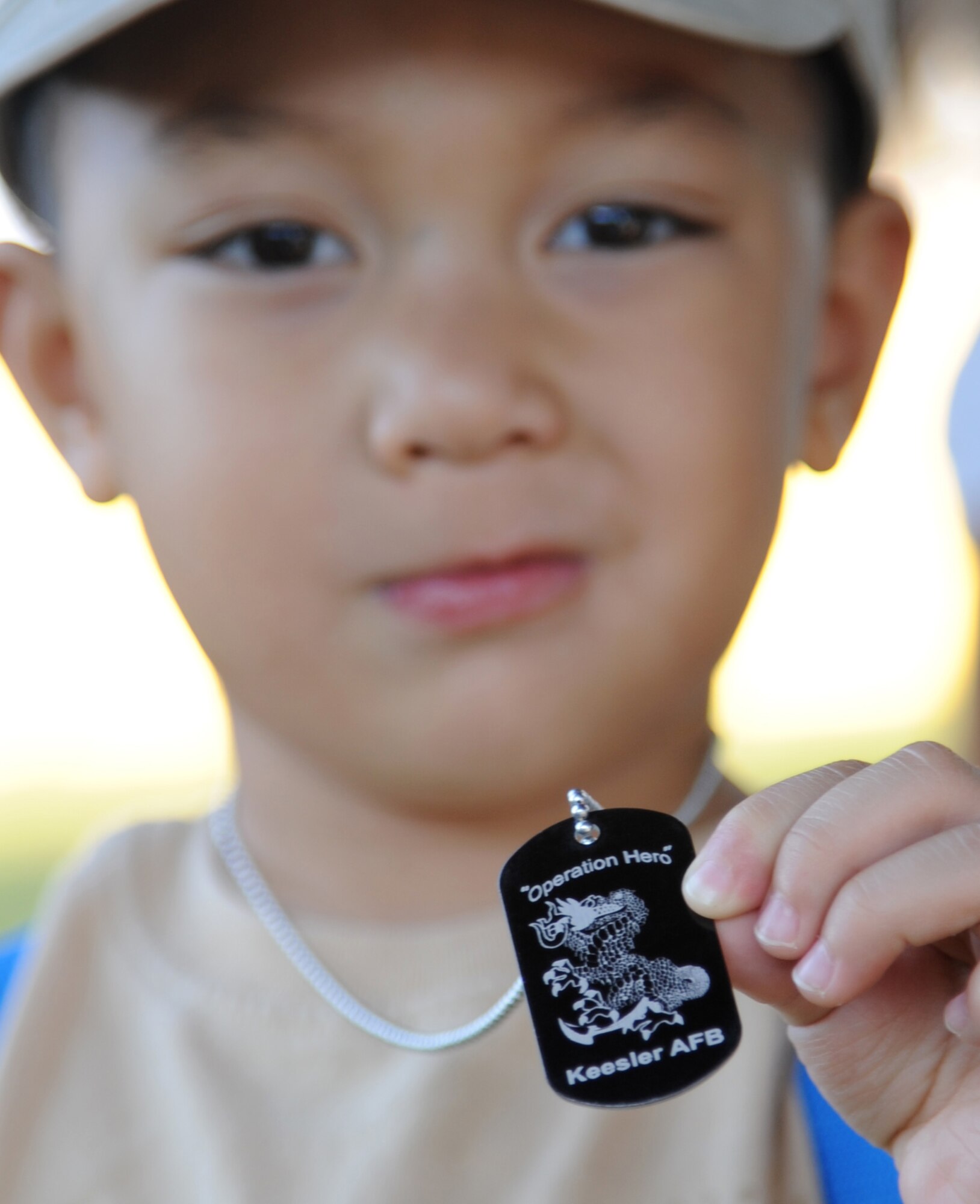 Three-year-old Christian Garcia, son of Hector Garcia and Tech. Sgt. Triscia Blas, 334th Training Squadron, displays the dog tags he received at Operation Hero Oct. 13, 2012, at Keesler Air Force Base, Miss.  Operation Hero is presented twice a year to give parents a chance to expose their children to what happens when they leave home for deployments tasking or on temporary duty.  (U.S. Air Force photo by Kemberly Groue)