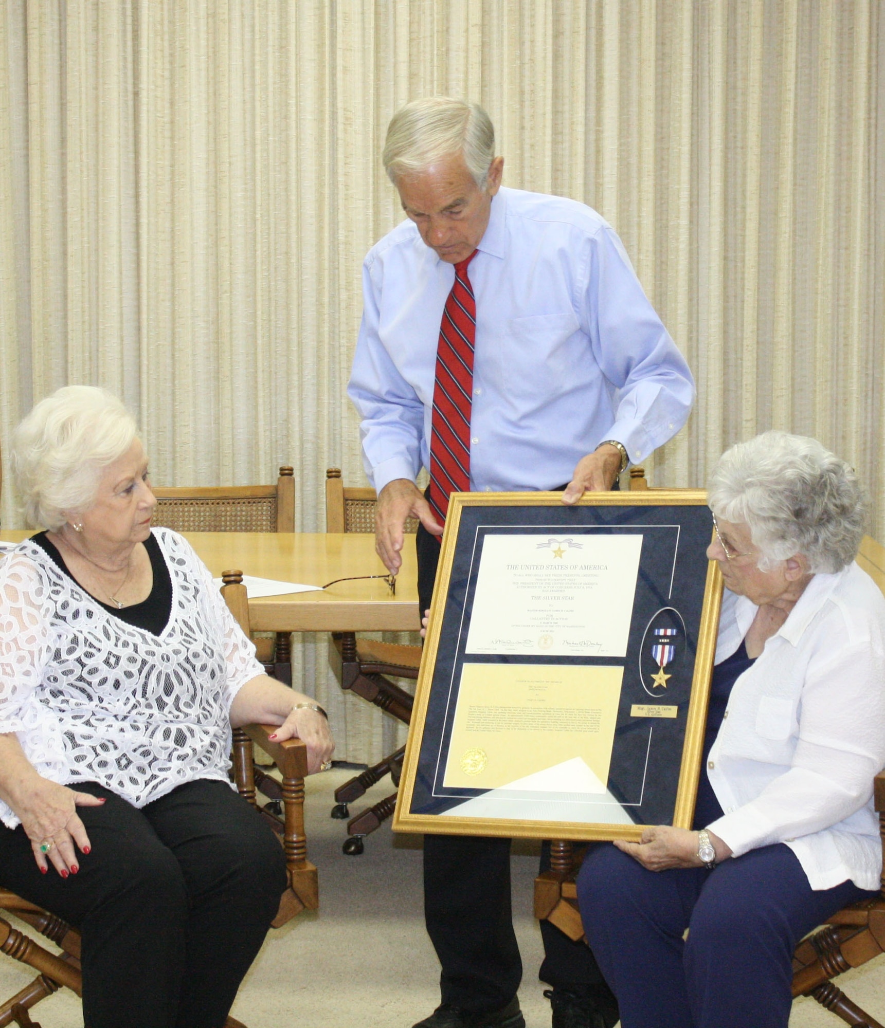 Rep. Ron Paul, center, presents a Silver Star medal and citation to Rosalie Bacica, left, and Frances Arrington at a ceremony in Lake Jackson, Texas, Aug. 16, 2012. Bacica and Arrington accepted the posthumous award on behalf of their brother, Master Sgt. James Calfee, who was killed March 11, 1968, when the North Vietnamese Army attacked Lima Site 85, a top secret Air Force radar site in Laos. (Photo courtesy of Rep. Ron Paul)