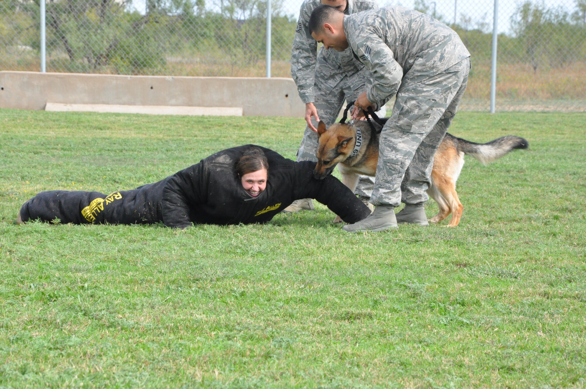 GOODFELLOW AIR FORCE BASE, Texas- Army Lt. Col. Devon Blake, 344th Military Intelligence Battalion commander, is taken down by one of the base Security Forces K-9 unit’s dogs at the Combined Federal Campaign finale Oct. 12, here. Base leaders volunteered to help out with the finale by dressing in protective wear and allowing, under a controlled environment, the trained dogs to attack and take them down while attendees made contributions to the CFC. (U.S. Air Force photo/ Airman 1st Class Erica Rodriguez)