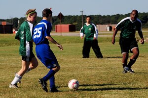 Michael Thorton, number 25 with the Norfolk Monarchs, rushes past members of the Newport News Striking Wolverines during the soccer portion of the Special Olympics at Langley Air Force Base, Oct. 13, 2012.  Approximately 70 military volunteers assisted the athletes in soccer, volleyball and bowling. (U.S. Air Force photo by Staff Sgt Ashley Hawkins/Released)