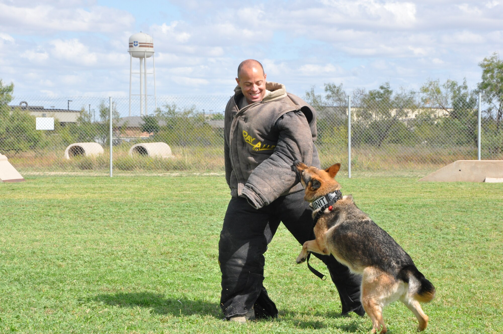 GOODFELLOW AIR FORCE BASE, Texas- Col. Mark Damiano, 17th Training Wing commander, lets one of the base Security Forces K-9 unit’s dogs take a bite at the Combined Federal Campaign finale Oct. 12, here.  Base leaders volunteered to help out with the finale by dressing in protective wear and allowing, under a controlled environment, the trained dogs to attack and take them down while attendees made contributions to the CFC. (U.S. Air Force photo/ Airman 1st Class Erica Rodriguez)