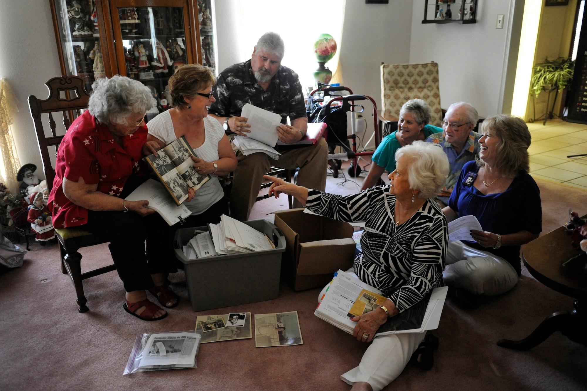 Relatives laugh as Debra Morris, second from left, a niece of the late Master Sgt. James Calfee, shows a photo of her uncle from his high school yearbook in Houston, Texas, Aug. 22, 2012. Calfee, who was posthumously awarded the Silver Star Medal, was killed in action in Laos in 1968. (U.S. Air Force photo/Val Gempis)